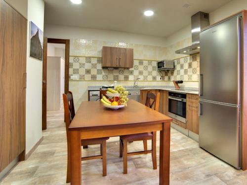 a kitchen with a wooden table with a bowl of fruit on it at Apartamentos La Jasa in Arguedas