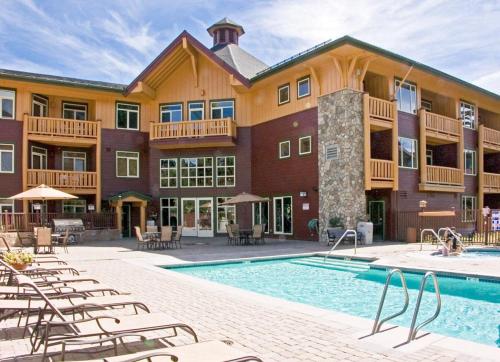 a resort with a pool and chairs and a building at Sunstone 325 in Old Mammoth