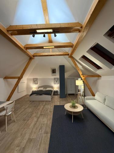 a loft conversion with a bed and a living room at Apartmán 19 in Mikulov
