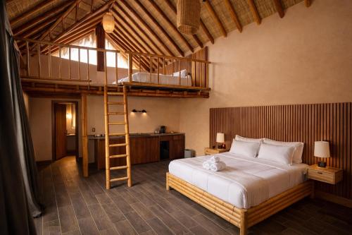 a bedroom with a loft bed and a ladder at Bambu Villas Wellness Center in Amatlán
