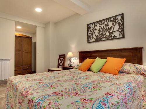 a bedroom with a bed with orange and green pillows at Apartamentos La Jasa in Arguedas