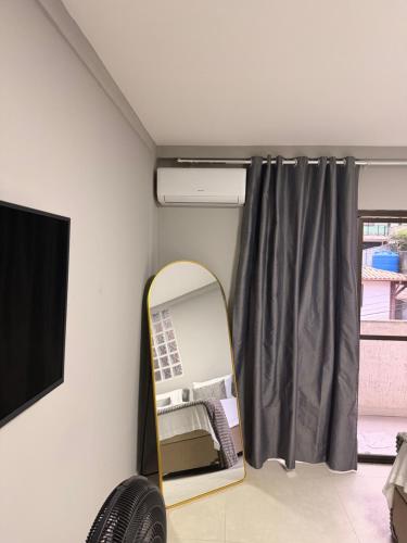 a mirror in a room next to a window at Serra Premium Residence in Petrópolis