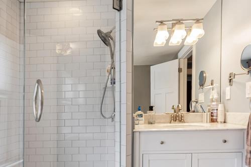 a bathroom with a sink and a shower with a mirror at Steps to Dtwn Plymouth! Home w/ Dog-Friendly Yard in Plymouth