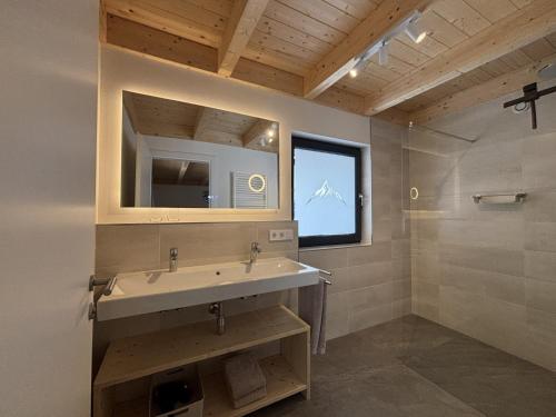 a bathroom with a sink and a mirror at Sportchalet Bergkristall regio Nassfeld Presseggersee in Kirchbach