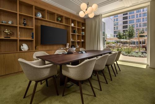 a dining room with a wooden table and chairs at DUO Hotel Lisbon, Curio Collection by Hilton in Lisbon