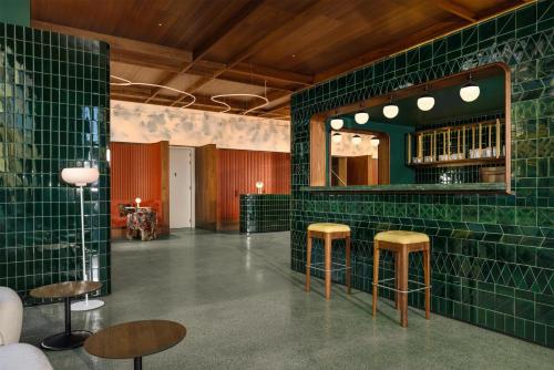 a bar with green tiled walls and stools at DUO Hotel Lisbon, Curio Collection by Hilton in Lisbon