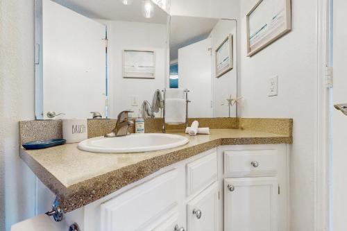 a bathroom with a sink and a mirror at Beach Club: The Lighthouse in Padre Island