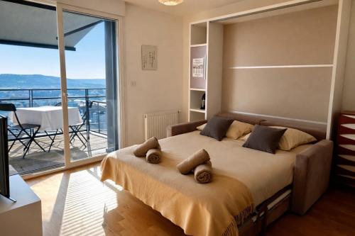 a bedroom with a large bed and a balcony at Le Clos Savignac in Trouville-sur-Mer
