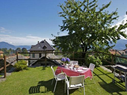 a table and chairs in a yard with a tree at Casetta dei Lupi in Miazzina