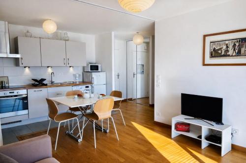 a kitchen and living room with a table and chairs at Le Clos Savignac in Trouville-sur-Mer