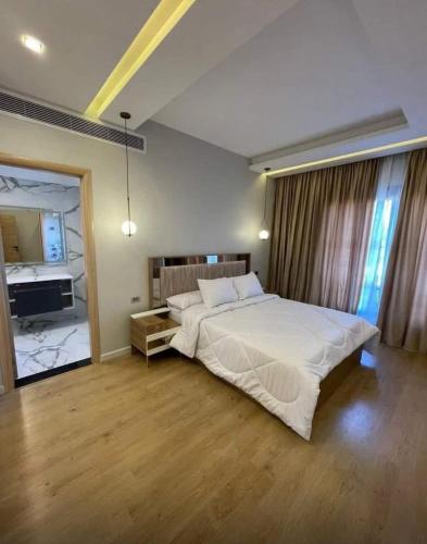 a large bedroom with a large bed and a bathroom at Gulf Suites Cairo in Cairo