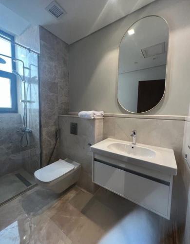 a bathroom with a sink and a toilet and a mirror at Gulf Suites Cairo in Cairo