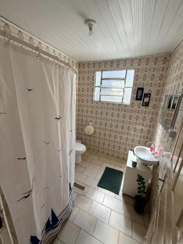 a bathroom with a shower and a sink and a toilet at Quarto 1 econômico Centro Itajaí in Itajaí