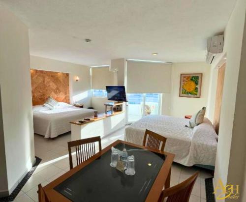a bedroom with two beds and a table with chairs at Angeles Suites & Hotel in Veracruz