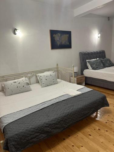 a bedroom with two beds and a chair at Themis Apartment in Kotor