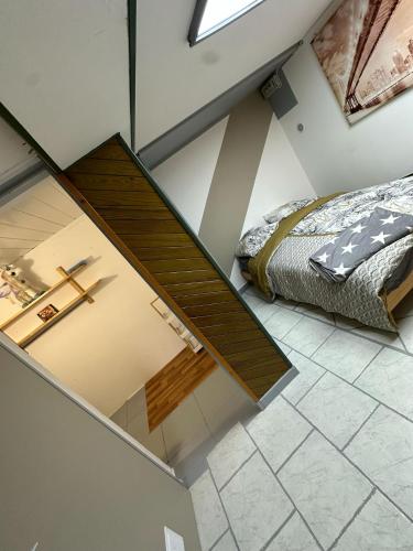 an attic bedroom with a bed and a window at Appartement familial de 60 M2 in Angoulême