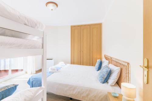 a bedroom with a bed and two bunk beds at Blue Horizon Apartment - Costa Alentejana in Santiago do Cacém
