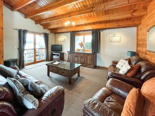 a living room with leather couches and a coffee table at Avocet Lodge in Horncastle
