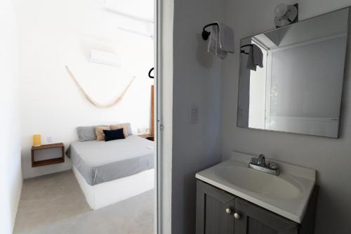 a bathroom with a bed and a sink and a mirror at Suku'un in Brisas de Zicatela