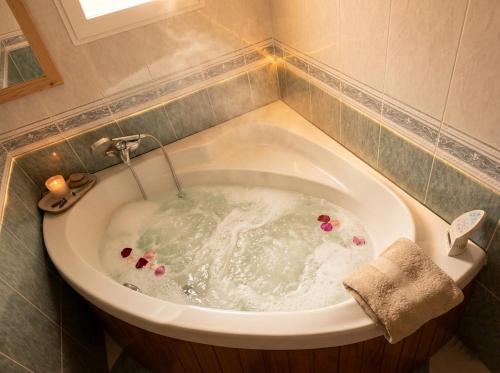 eine Badewanne mit Blumen darin in einem Badezimmer in der Unterkunft Casa El Pedernal in Basardilla