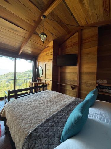 a bedroom with a bed with blue pillows on it at Vista Encantada Hotel in Villa Canales