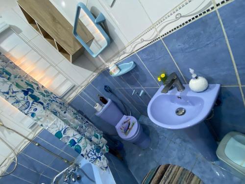 a blue bathroom with a sink and a toilet at Flamingo 1 spacious solar powered 2 bedroom home with a stocked ready kitchen in Jos