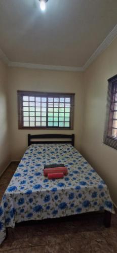 a bedroom with a bed with two red pillows on it at Canto dos Pássaros in Brasília