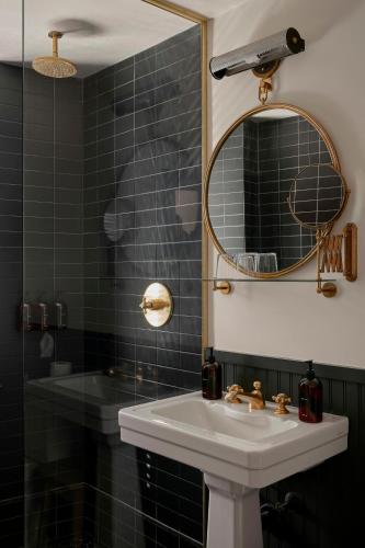 ein Badezimmer mit Waschbecken und Spiegel in der Unterkunft Neptune, an Ash Hotel in Providence