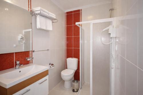 a bathroom with a toilet and a sink and a shower at Bybassios Orhaniye in Orhaniye