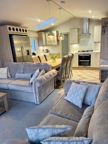 a living room and kitchen with couches and a table at Rockley Park, Poole, Stunning Sea View, Close to Beach in Poole