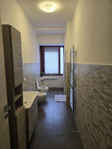 a bathroom with two sinks and a toilet and a tub at Casa Roncalli 19-A in Foligno