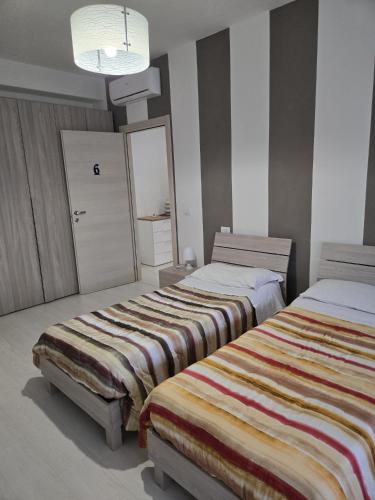 a bedroom with two beds and a mirror at Casa Roncalli 19-A in Foligno