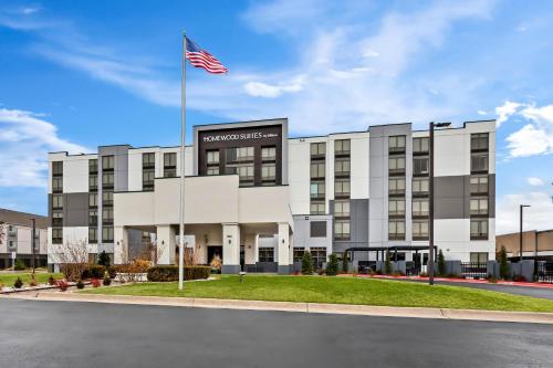 an office building with an american flag in front at Homewood Suites by Hilton Oklahoma City Airport in Oklahoma City
