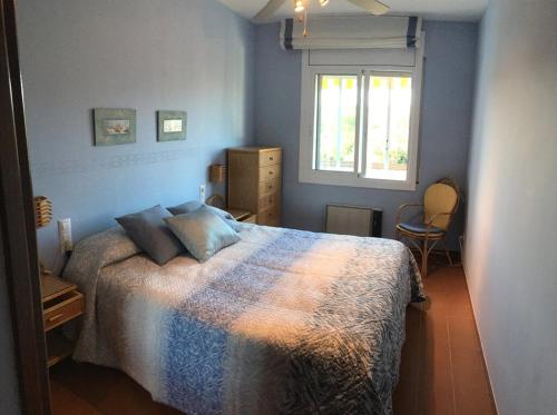 a blue bedroom with a bed and a window at Coma-ruga in Comarruga