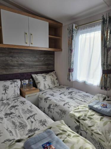 a bedroom with two beds and a window at Pine Ridge B6 in Reighton