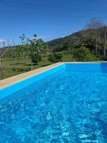 a blue swimming pool with a view of a mountain at Casa dos Avós in Póvoa de Lanhoso