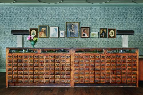 a large wooden display cabinet with pictures on a wall at Graduate by Hilton Charlottesville in Charlottesville