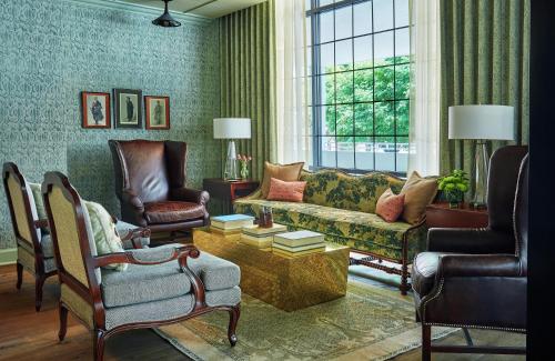 a living room with a couch and two chairs at Graduate by Hilton Charlottesville in Charlottesville