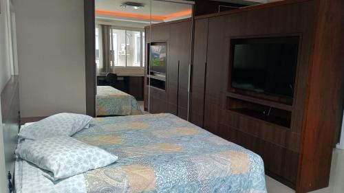 a bedroom with two beds and a flat screen tv at Private Suite Confortable Stay in Florianópolis