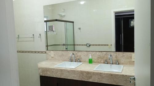 a bathroom with two sinks and a large mirror at Private Suite Confortable Stay in Florianópolis