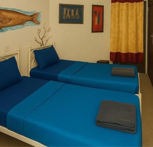 a room with a blue bed and a couch at Ecogîte Dégg-Jàmm in Mbour