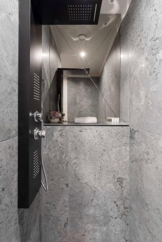 a shower with a glass door in a bathroom at R2 apartman in Kecskemét