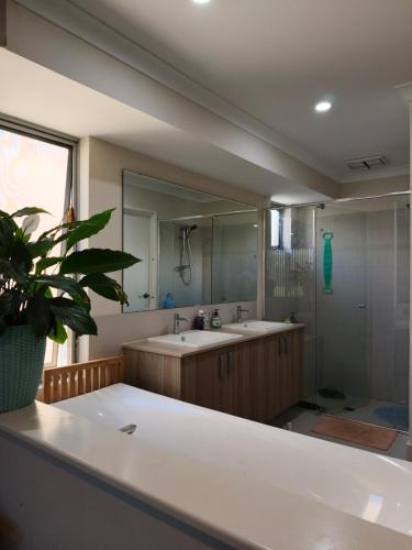 a bathroom with a sink and a large mirror at Piara Sojourn in Perth