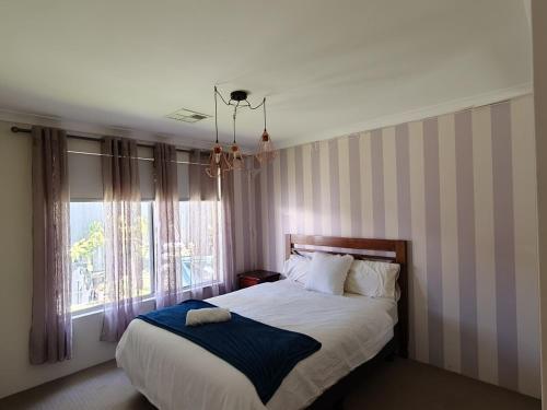 a bedroom with a bed and a window at Piara Sojourn in Perth