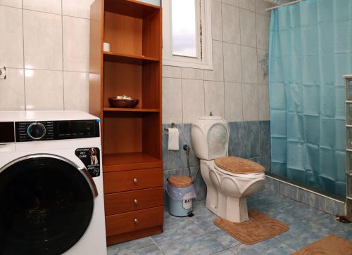 a bathroom with a toilet and a washing machine at AnastasiaSunsetView in Souda