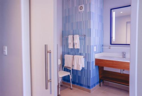 a bathroom with a sink and a mirror and a counter at Tru By Hilton Puebla Angelopolis in Puebla