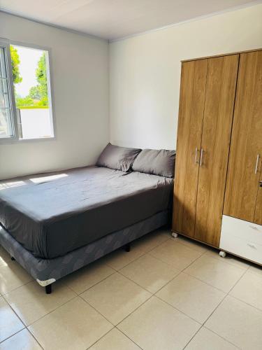 a bedroom with a bed and a wooden cabinet at Casa Yasmin in San Mateo