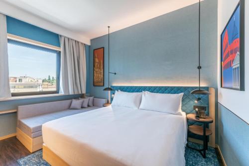 a hotel room with a large bed and a window at Hilton Garden Inn Rome Colosseum in Rome