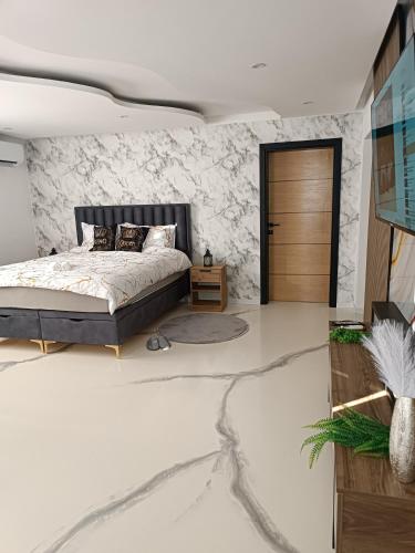 a bedroom with a bed and a stone wall at Jacuzzi Apartman in Karuše