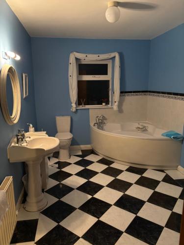 a bathroom with a tub and a sink and a toilet at Fiona's Country Accommodation in Murphyʼs Bridge